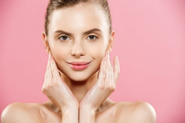 Beauty Concept - Close up Portrait of attractive caucasian girl with beauty natural skin isolated on pink background with copy space.